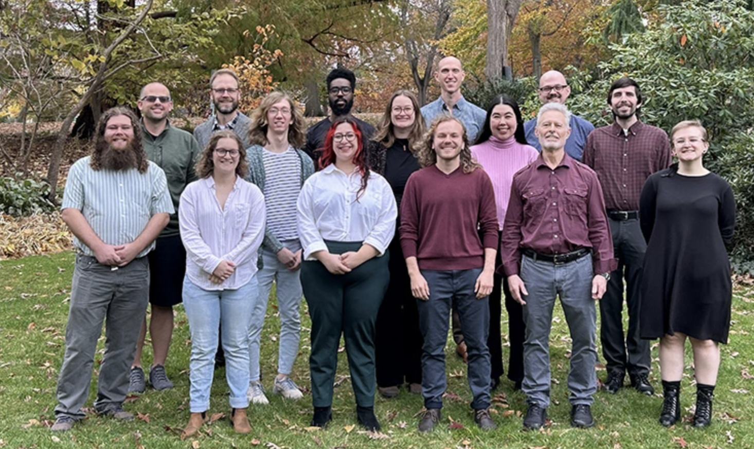 A group photo of the faculty of the College of Music. The group stands outside in three rows, smiling at the camera.